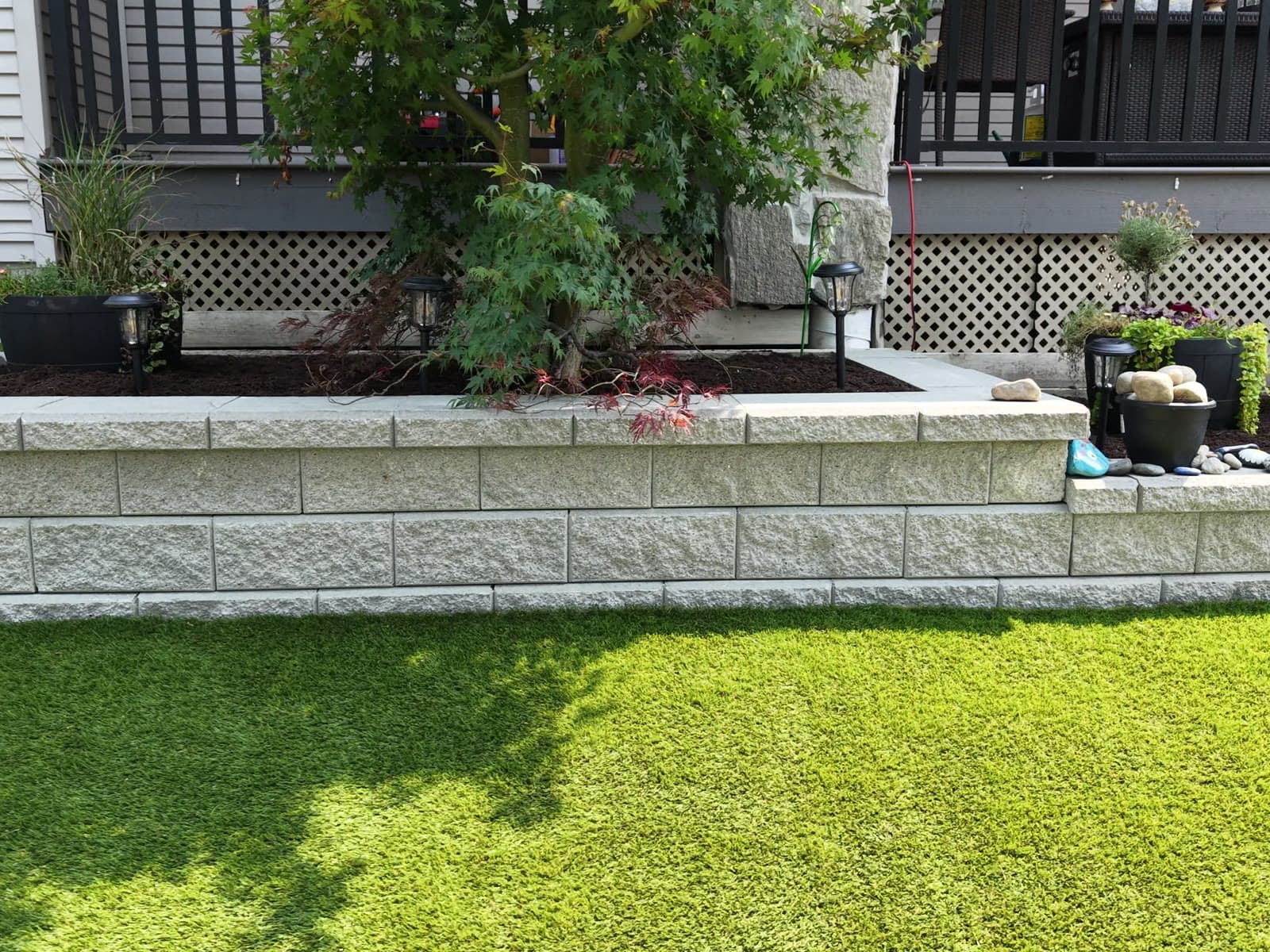 Finished Allan Block retaining wall, planter bed and artificial turf on a real Daedalus Contracting job in Maple Ridge, BC